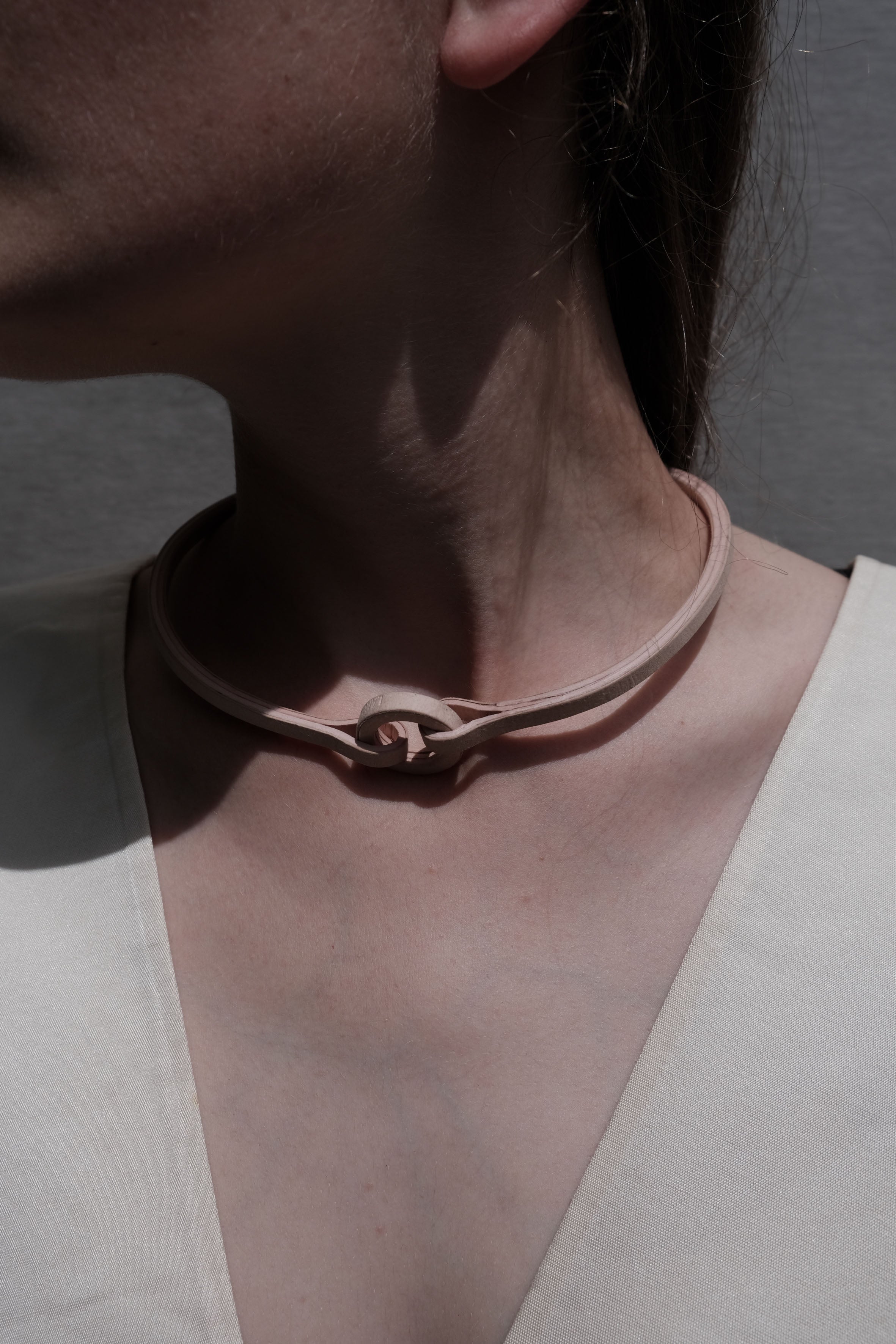 Langackerhäuslの身に纏うアート「HALSI(ハルシ)ネックレス」。一本の細いラインと中央の小さな円環モチーフが美しい、ヌードカラーの超軽量ハンドメイドチョーカー。Tバー式の留め具を採用したオーストリア製ジュエリー。